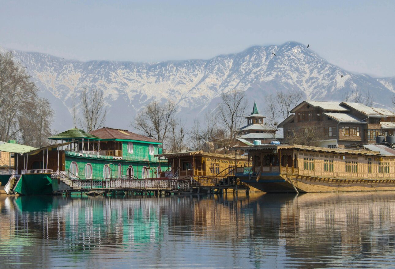 Kashmir Dal Lake houseboat with mountains at sunrise