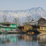 Kashmir Dal Lake houseboat with mountains at sunrise