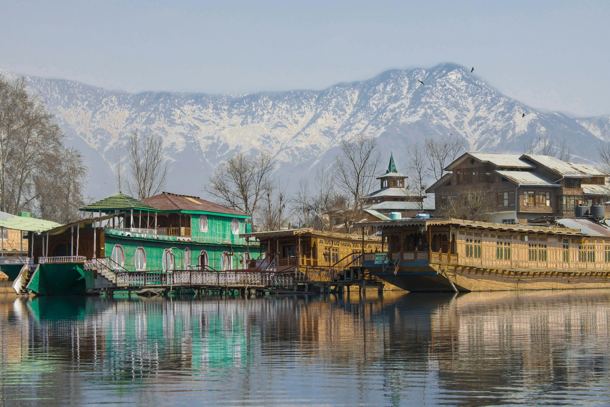 Kashmir Dal Lake houseboat with mountains at sunrise